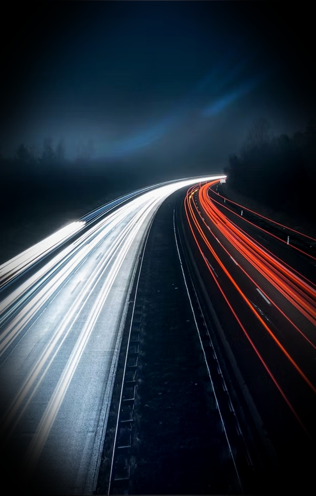 Long-exposure Miami highway at night — white headlight streaks on one side, red taillight trails on the other